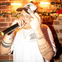 Mannix on the mic in a white cap